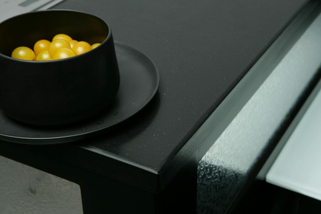 Black kitchen countertop with bowl containing yellow pearls 